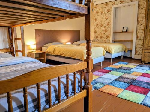 a bedroom with two bunk beds and a rug at Gîtes Le Verger in Taintrux