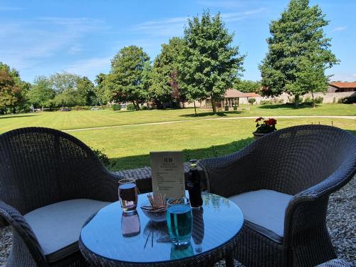 two chairs and a table with drinks on it at Chambres d'Hôtes Manoir de Beaumarchais in Les Chapelles-Bourbon