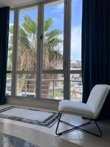 a white chair sitting in front of a window at Cactus Apartments in Durrës