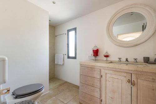 bagno con servizi igienici, lavandino e specchio di Lamia Madreperla by BarbarHouse a San Vito dei Normanni
