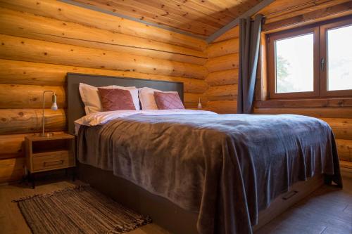 sypialnia z łóżkiem w drewnianym domku w obiekcie Vucje Brdo in Kolasin w mieście Kolašin