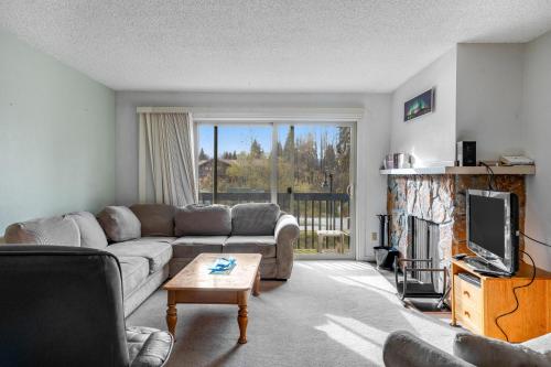 a living room with a couch and a fireplace at Olympic Loop 405S in Girdwood