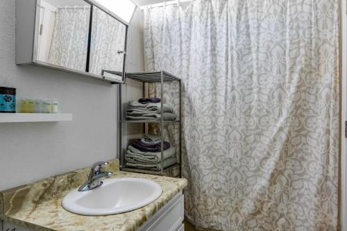 a bathroom with a sink and a shower curtain at Olympic Loop 405S in Girdwood
