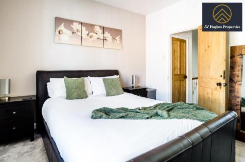 a bedroom with a white bed with a green blanket at Spacious Victorian House By AV Hughes Properties Short Lets & Serviced Accommodation Northampton with Fast Wi-Fi and Free Parking in Northampton
