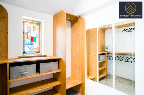 a room with wooden shelves and a window at Spacious Victorian House By AV Hughes Properties Short Lets & Serviced Accommodation Northampton with Fast Wi-Fi and Free Parking in Northampton