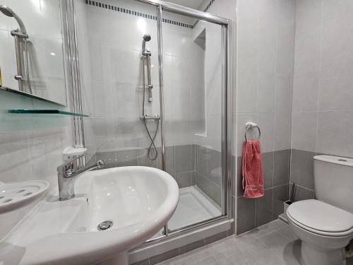 a bathroom with a shower and a sink and a toilet at Stunning Seafront Portomaso Apartment in Paceville