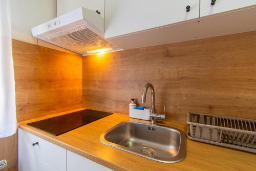 uma cozinha com um lavatório e uma parede de madeira em Flexible SelfCheckIns 57 - Zagreb - Parking - New em Zagreb