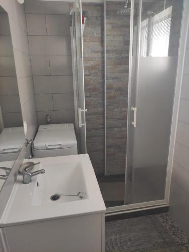 a bathroom with a toilet and a sink and a shower at La Siesta Apt in Salou