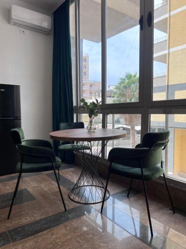 a table and chairs in a room with a large window at Cactus Apartments in Durrës