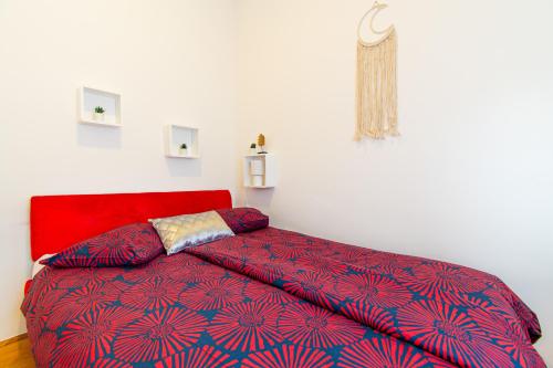 um quarto com uma cama com uma cabeceira vermelha em Flexible SelfCheckIns 57 - Zagreb - Parking - New em Zagreb