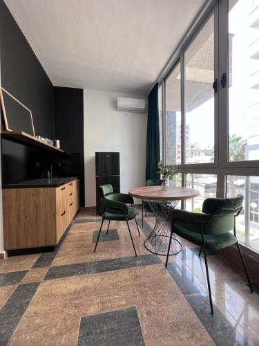 a living room with a table and chairs and a large window at Cactus Apartments in Durrës