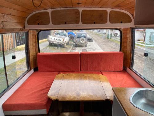 widok na tył vana z ławką i stołem w obiekcie Camperbus Apawata w mieście Puerto Natales