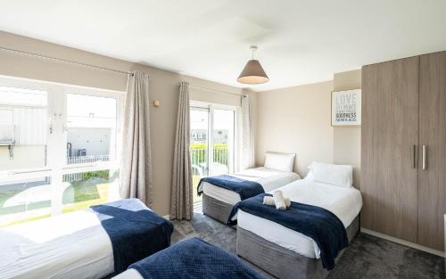 um quarto de hotel com três camas e uma janela em Riverside Townhouse Carrick em Carrick on Shannon