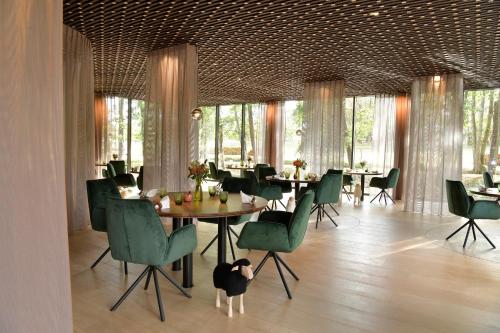 a dining room with tables and green chairs at Château de Vault de Lugny in Vault-de-Lugny