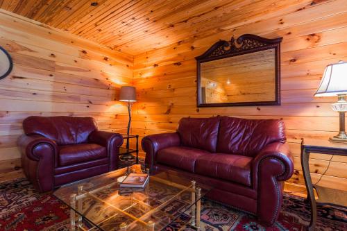 a living room with two leather couches and a table at Christmas Tree Cabin Secluded Asheville Area Log Cabin with a View! in Old Fort