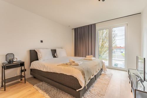 Un dormitorio con una cama grande y una ventana en Modern & Spacious House, en Cortrique