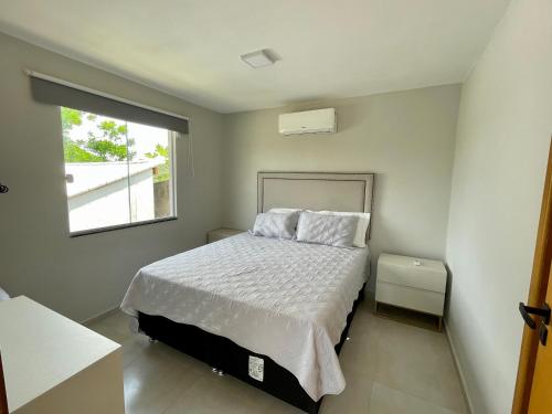 um quarto com uma cama e uma janela em Chacara em Ubatiba-Maricá em Maricá