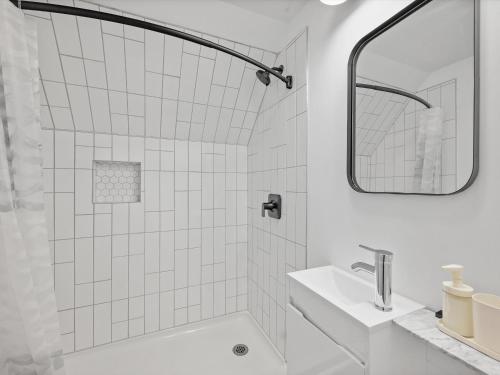 a white bathroom with a sink and a shower at Shadyside, Pittsburgh, Modern and Unique 1 Bedroom Unit6 with Free Parking in Pittsburgh