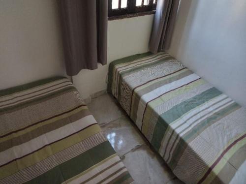two beds sitting in a corner of a room at Casa Inteira e Tranquila em Taboão da Serra in Taboão da Serra