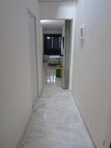 a long hallway with a room with a bed in it at Casa Inteira e Tranquila em Taboão da Serra in Taboão da Serra