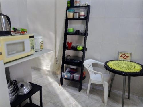 a small kitchen with a table and a microwave at Casa Inteira e Tranquila em Taboão da Serra in Taboão da Serra