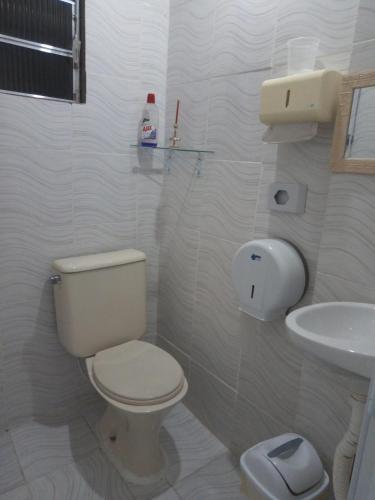 a white bathroom with a toilet and a sink at Casa Inteira e Tranquila em Taboão da Serra in Taboão da Serra