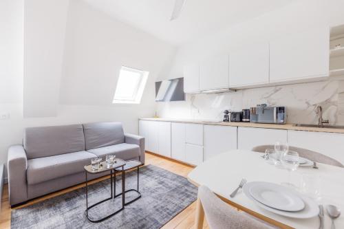 a living room with a couch and a table at Cosy Studio Etoile Friedland - MOBILITY LEASE in Paris