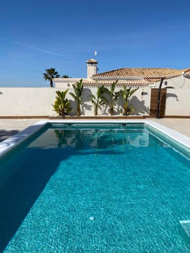 a swimming pool in front of a house at Pink Lagoon Villa in Torrevieja