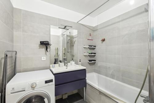 y baño con lavadora y lavamanos. en Chic apart with parking near Paris, en Rueil-Malmaison