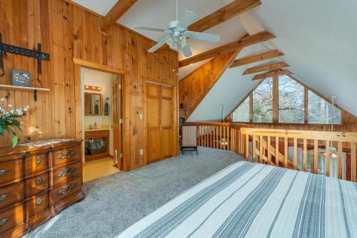 um quarto com uma ventoinha de tecto e paredes de madeira em Cozy Cove Cabin Pet Friendly & Creek Access em Marion