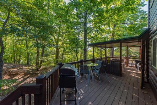 a deck with a grill and a table and chairs at Summit Sunsets Pets & Year-Round Mountain Views! in Marion