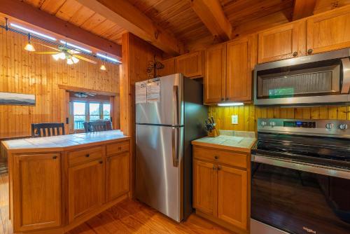 a kitchen with a stainless steel refrigerator and a stove at Summit Sunsets Pets & Year-Round Mountain Views! in Marion