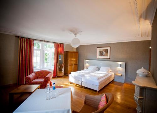 1 dormitorio con 1 cama, mesa y sillas en Chateau De Strainchamps en Fauvillers