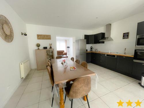 une cuisine avec une table et des chaises dans une pièce dans l'établissement Le Clos Des Oyats a Bleriot-Plage, à Sangatte Blériot-Plage