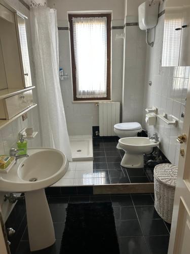 Baño blanco con 2 lavabos y aseo en Casa Capoleto, en Torre le Nocelle
