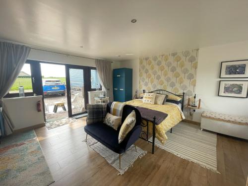 a bedroom with a bed and a couch and a chair at The Hive at Seonaidbheag in Perth