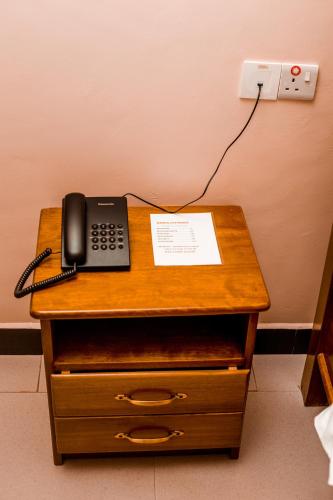 a telephone sitting on top of a wooden table at Randa Family House - Moshi in Himo