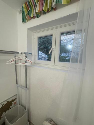a bathroom with a window and a shower curtain at La grande bellezza in Martinšćica