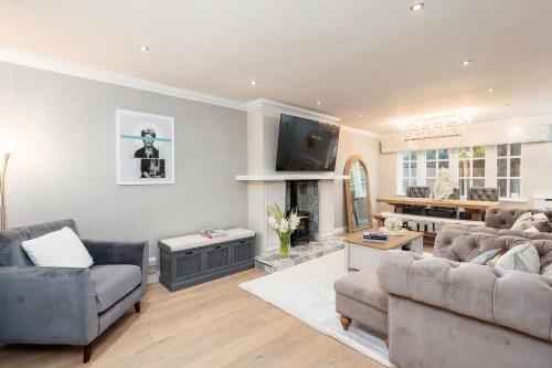 a living room with two couches and a tv at 4 Bedroom, 7 Bed, 2.5 Bath - Detached House in Cheadle
