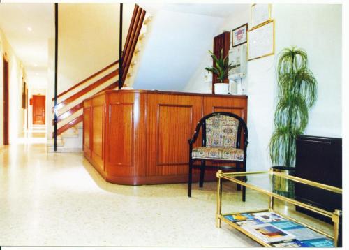 a hallway with a chair and a glass table at Hostal Niza in Badajoz