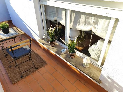 a balcony with a window with potted plants on it at Evans Realty AT Ático & Centro & Playa & Vistas mar in Fuengirola