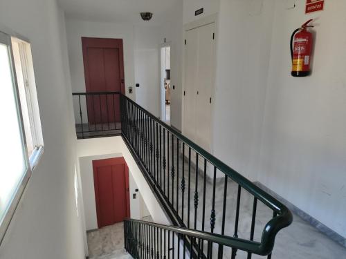 a stairway with a green rail and two red doors at Evans Realty AT Ático & Centro & Playa & Vistas mar in Fuengirola