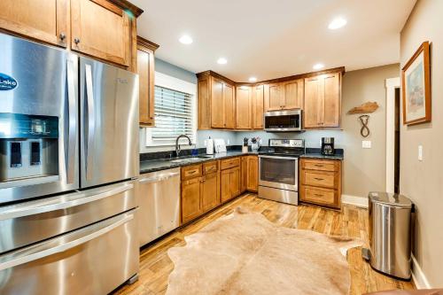 a kitchen with wooden cabinets and stainless steel appliances at Nolin Lake Home with Hot Tub 15 Mi to Mammoth Cave! in Cub Run