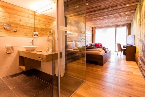 een badkamer met een douche, een wastafel en een bed bij Riverside in Zweidlen