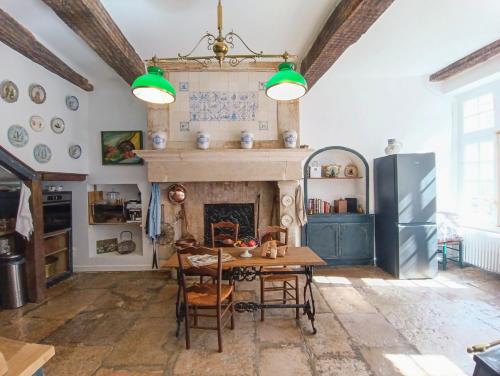 une salle à manger avec une table et une cheminée dans l'établissement QUELQUES JOURS À NOYERS SUR SEREIN, à Noyers-sur-Serein