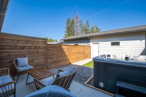 a backyard with a fence and a table and chairs at Serene Peaks, Private Hot Tub, Peaceful in Radium Hot Springs