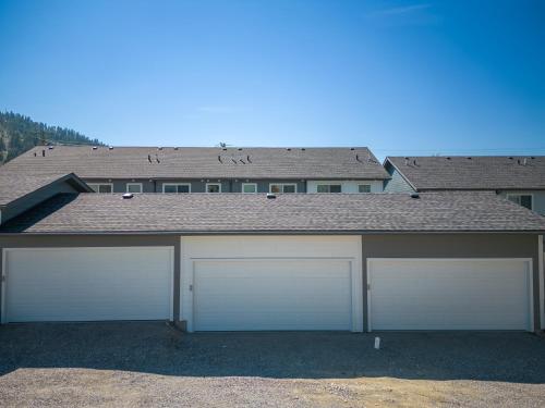 a house with two garage doors in front of it at Serene Peaks, Private Hot Tub, Peaceful in Radium Hot Springs