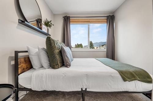 a bedroom with a bed with a mirror and a window at Serene Peaks, Private Hot Tub, Peaceful in Radium Hot Springs