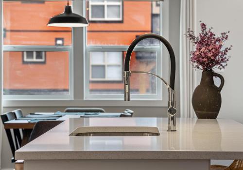 a kitchen with a sink and a vase with flowers on a counter at Serene Peaks, Private Hot Tub, Peaceful in Radium Hot Springs