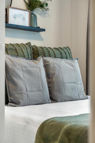 a bed with three pillows on top of it at Serene Peaks, Private Hot Tub, Peaceful in Radium Hot Springs